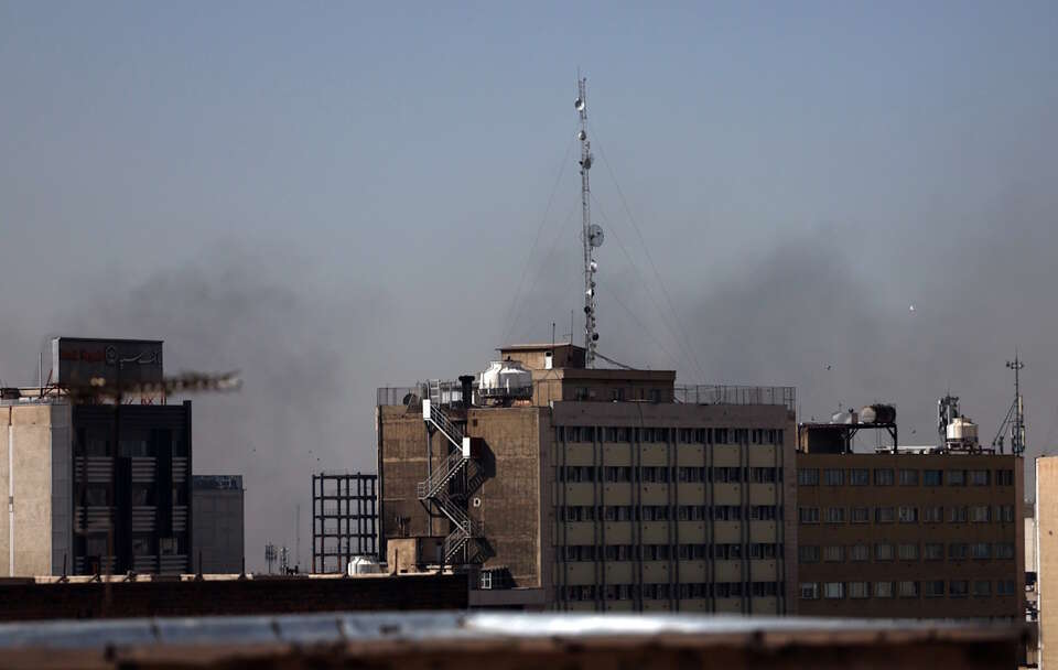 Na zdjęciu dym budynki w Iranie na tle dymu po ataku USA / autor: PAP/EPA