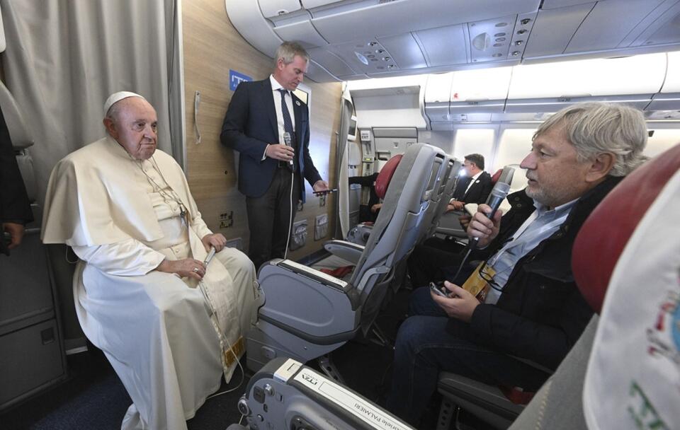 Papież Franciszek rozmawiający z dziennikarzami podczas konferencji na pokładzie samolotu / autor: PAP/EPA/CIRO FUSCO / POOL