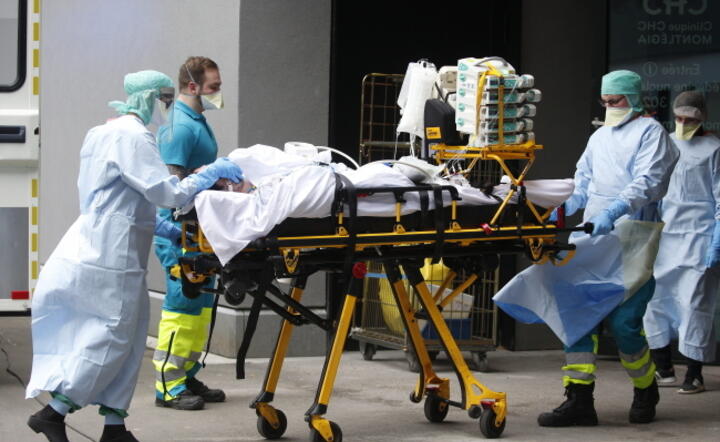 Pacjent z objawami choroby COVID-19 transportowany do szpitala MontLegia koło Liege / autor: PAP/EPA/JULIEN WARNAND