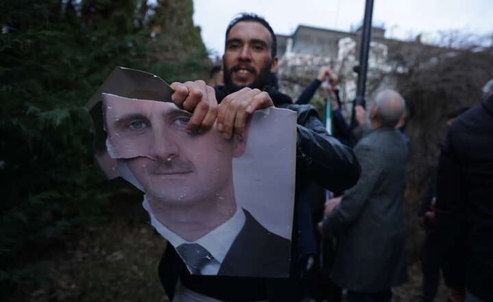 Demonstrant niszczący plakat z portretem Baszara al-Asada / autor: PAP/EPA/ANDREJ CUKIC