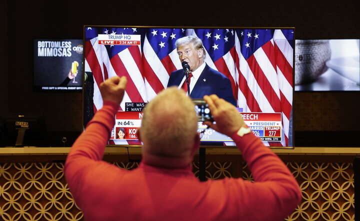 Ludzie zgromadzeni w hotelu w Las Vegas oglądają w tv wystąpienie Donalda Trumpa / autor: PAP/EPA/CAROLINE BREHMAN