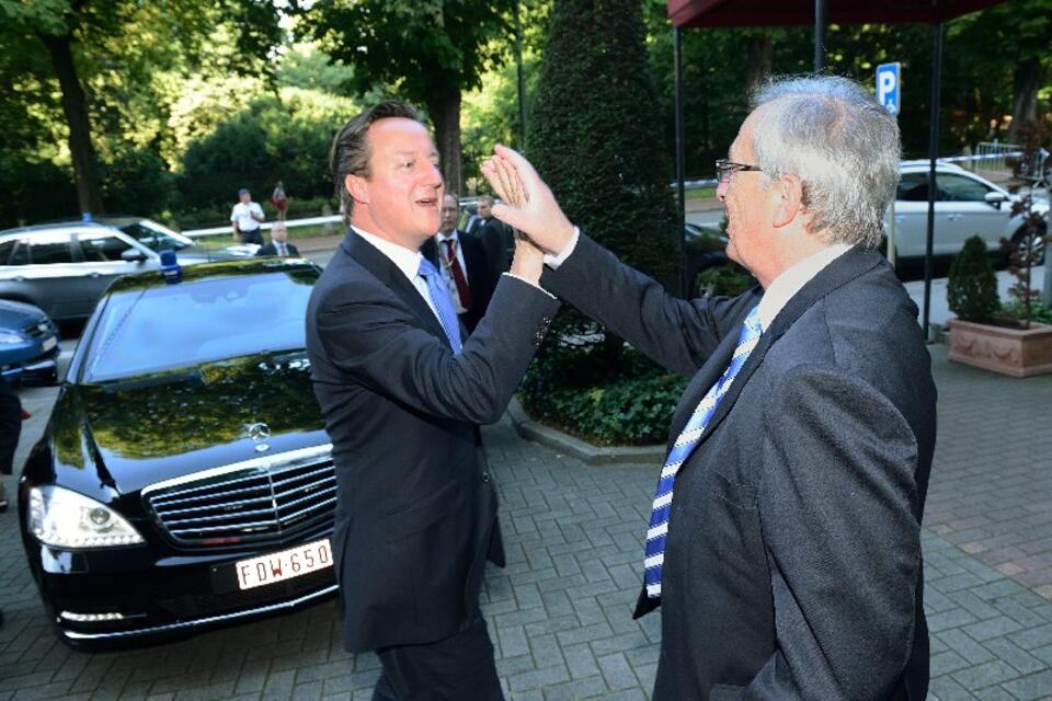 Premier Wielkiej Brytanii David Cameron wita się z Junckerem, którego nominację starał się - nieskutecznie - zablokować. PAP/EPA