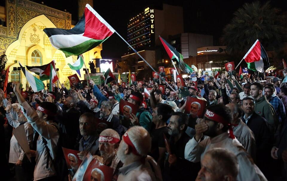 Irańscy zwolennicy Hezbollahu machają palestyńskimi flagami podczas "świętowania" po atakach Hamasu na Izrael / autor: PAP/EPA