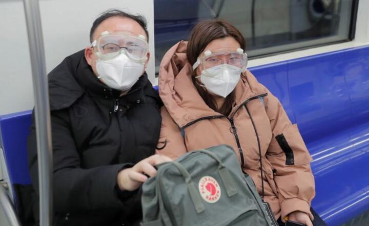 Mieszkańcy Pekinu w maskach i okularach ochronnych w wagonie metra , Chiny, 25 stycznia 2020 r.  / autor: PAP/EPA/WU HONG