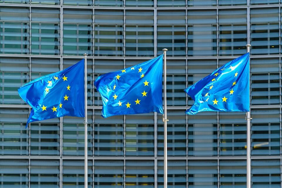 Flagi UE na masztach, w tle budynek KE / autor: Fratria