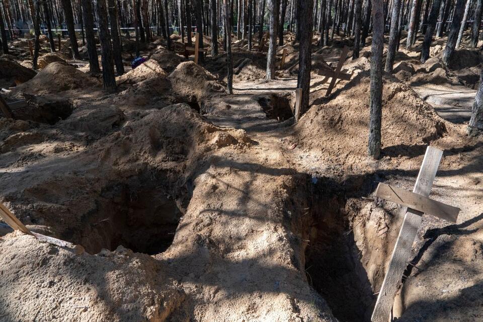 Masowe groby w lesie w mieście Izium / autor: PAP