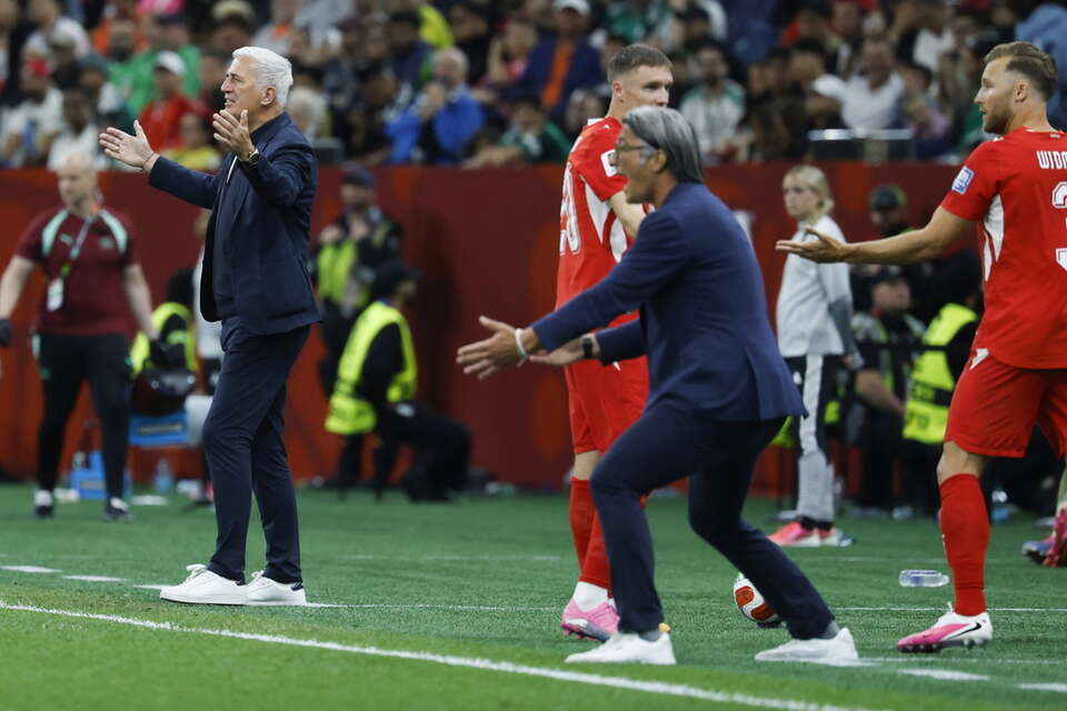 Trenerzy na linii bocznej podczas meczu piłki nożnej 32. rundy Pucharu Świata pomiędzy Szwajcarią a Algierią na stadionie BC Place w Vancouver w Kanadzie / autor: PAP/EPA