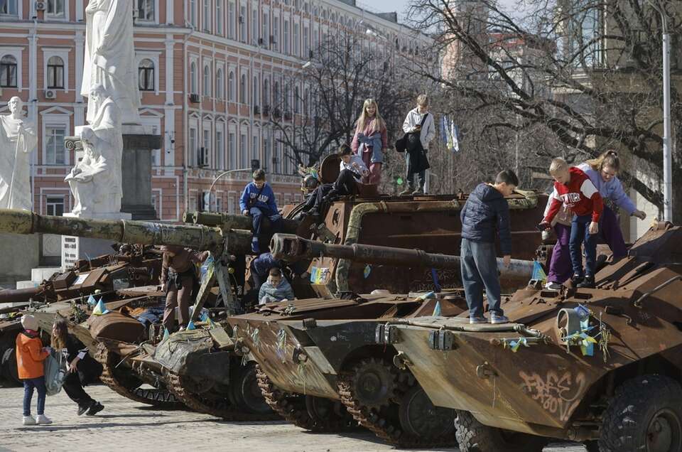 Dzieci bawią się na pojazdach bojowych wystawionych na wystawie zniszczonego rosyjskiego sprzętu wojskowego w Kijowie / autor: PAP/EPA