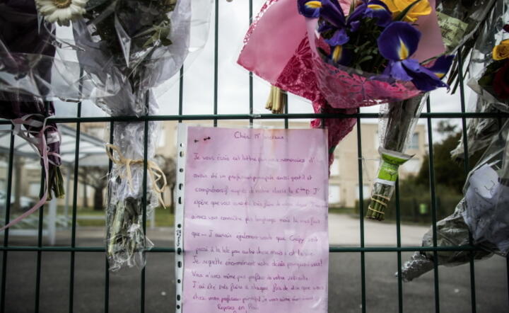 Francja: kwiaty i list pożegnalny dla Dominique Varoteaux, 60-letniej nauczycielki liceum Jean de la Fontaine  Crepy-en-Valois pod Paryżem, która zmarła po zarażeniu się wirusem / autor: PAP/EPA/CHRISTOPHE PETIT TESSON