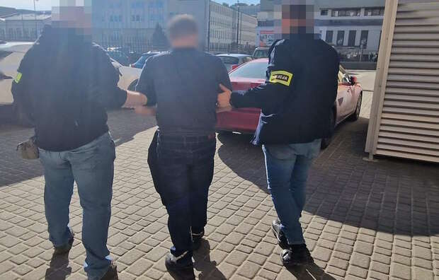 Na zdjęciu zatrzymany 40-latek, który groził wysadzeniem bloku, prowadzony przez dwóch funkcjonariuszy / autor: Policja