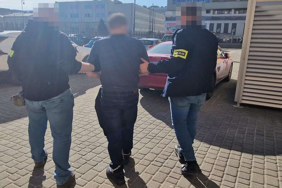 Na zdjęciu zatrzymany 40-latek, który groził wysadzeniem bloku, prowadzony przez dwóch funkcjonariuszy / autor: Policja