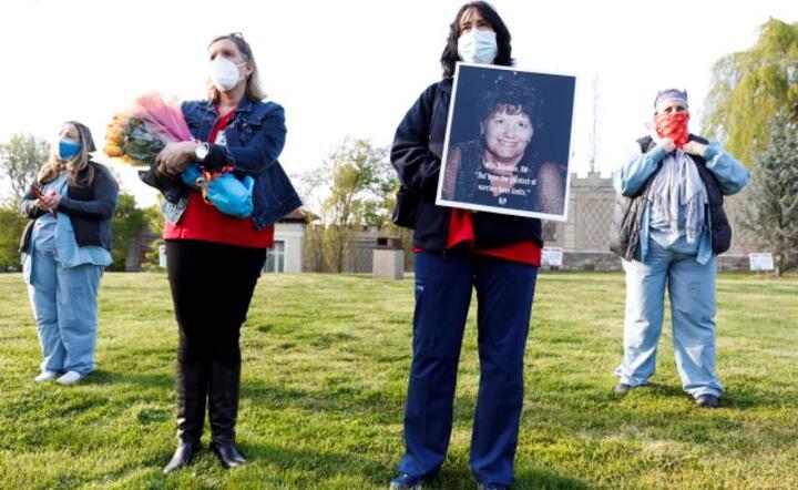 Pielęgniarka Lorraine Gibson (2-R) trzyma fotografię Mari Donahue, emerytowanej pielęgniarki, która zmarła na COVID-19 w tym miesiącu, Nowy Jork / autor: PAP/EPA/JUSTIN LANE