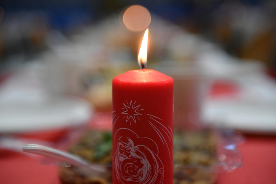 Tradycyjna świeca Caritas na wigilijnym stole podczas spotkania, organizowanego dla osób potrzebujących przez Caritas Archidiecezji Gdańskiej w sopockiej Hali Stulecia. / autor: PAP/Adam Warżawa