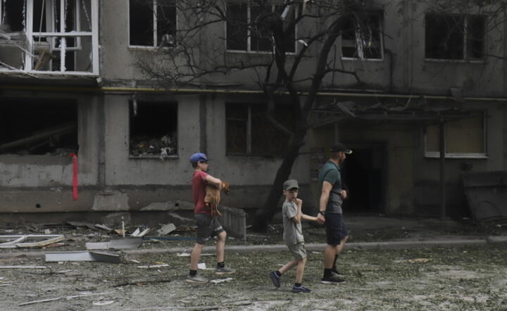  Mieszkańcy  obok budynku mieszkalnego uszkodzonego podczas niedawnego ostrzału w mieście Bachmut w obwodzie donieckim na wschodzie Ukrainy, 13 czerwca 202 / autor: PAP/EPA/STRINGER