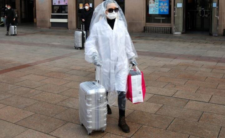 Pasażerowie w odzieży ochronnej i maskach na lotnisku w Pekinie  / autor: PAP/EPA/WU HONG