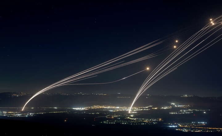 Pociski wystrzelone w ramach izraelskiej Żelaznej Kopuły "przejmują" rakiety wypalone w kierunku tego kraju / autor: PAP/EPA/ATEF SAFADI