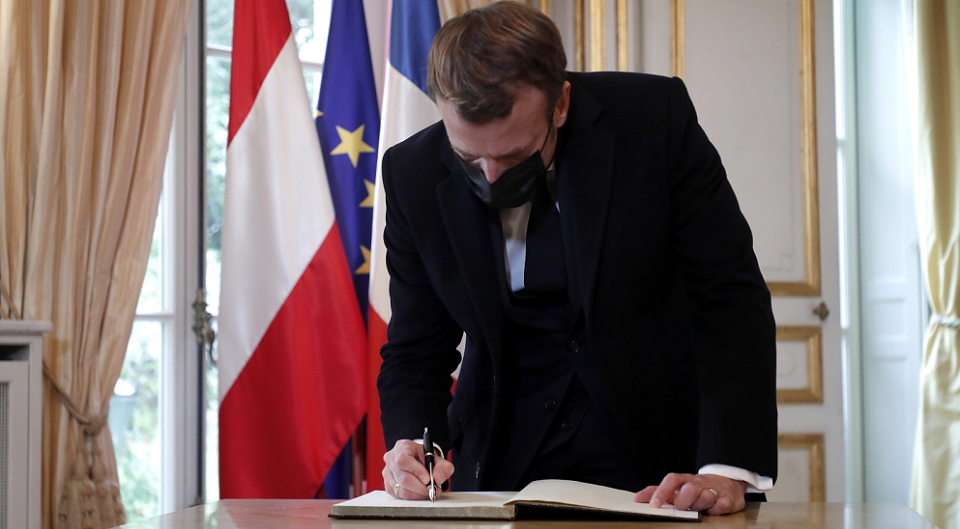 Prezydent Francji Emmanuel Macron wpisuje się do księgi kondolencyjnej wyłożonej w ambasadzie Austrii w Paryżu / autor: PAP/EPA