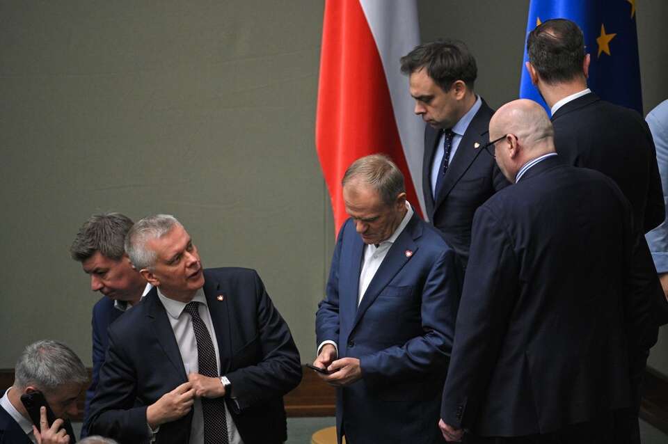 Premier Donald Tusk (C), szef KPRM Jan Grabiec (2L), szef MSWiA Tomasz Siemoniak (3L) oraz minister finansów Andrzej Domański (3P) na sali plenarnej Sejmu. / autor: PAP/Marcin Obara