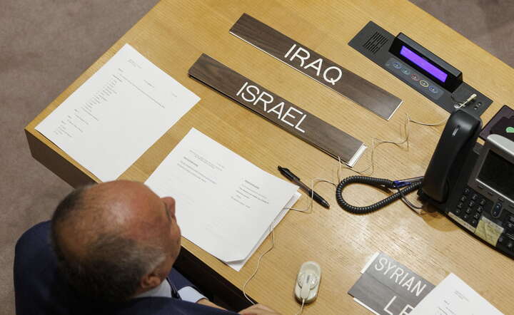 Pracownik Organizacji Narodów Zjednoczonych rozkłada materiały, w tym tabliczki z nazwami państw Iraku i Izraela, przed posiedzeniem Rady Bezpieczeństwa w siedzibie ONZ w Nowym Jorku / autor: PAP