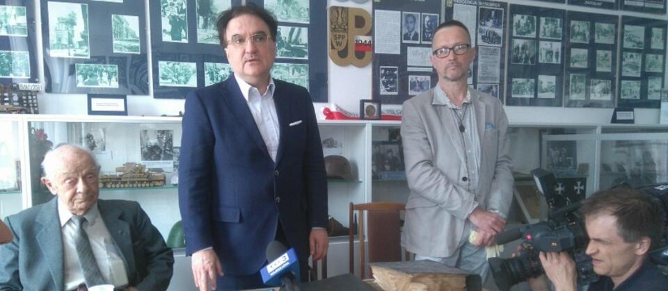Rafał Szczepański (w środku) prezentuje unikalne niemieckie dokumenty 'Raport o Warszawie' / autor: wPolityce.pl