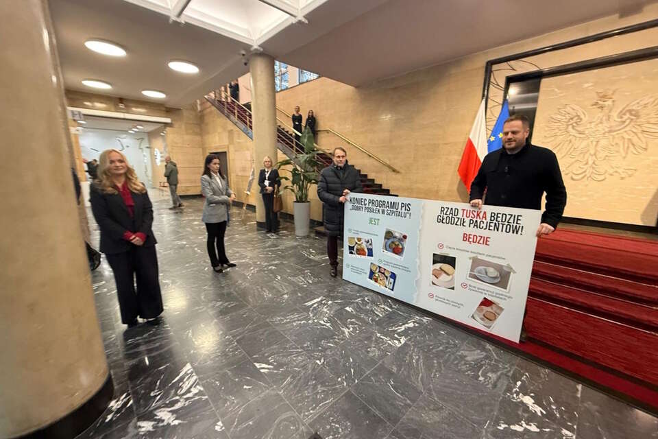 Poseł PiS Janusz Cieszyński z banerem podczas rządowego medycznego szczytu / autor: Janusz Cieszyński (media społecznościowe)