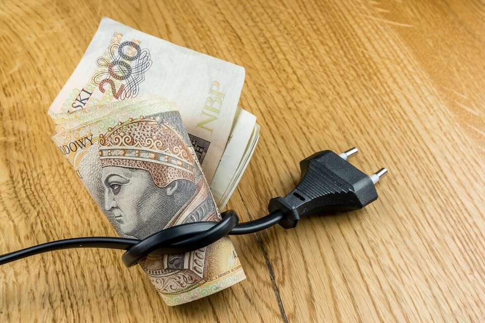 zdjęcie ilustracyjne, banknot 200 zł owinięty w przewód elektryczny z wtyczką - od 1 stycznia będziemy mieli do czynienia ze średnią podwyżką cen energii elektrycznej w wysokości 10 proc. / autor: Fratria