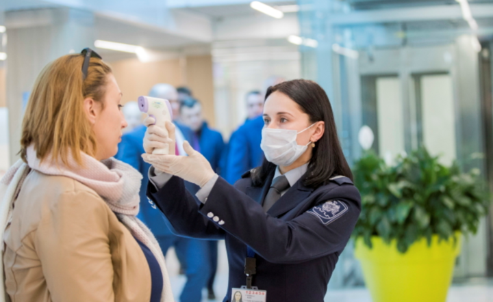 Urzędnicy imigracyjni wykonują skanowanie termiczne pasażerów przybywających na lotnisko w Kiszyniowie w Mołdawii w dniu 25 lutego 2020 r. / autor: PAP/EPA/DUMITRU DORU