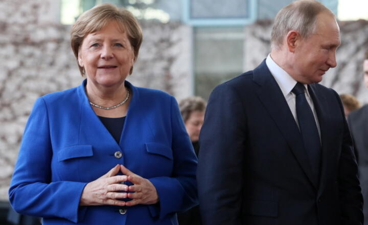 Prezydent Rosji Władimir Putin (w środku) wymownie spogląda na kanclerz Niemiec Angele Merkel (odwrócona tyłem). Zdjęcie z 19 stycznia 2020 r., zrobione na odbywającej się w Berlinie konferencji na temat Libii / autor: PAP/EPA/HAYOUNG JEON