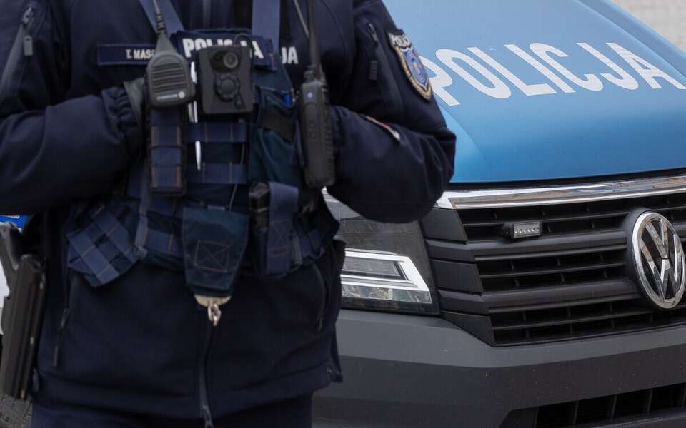Policjant na tle radiowozu / autor: Fratria