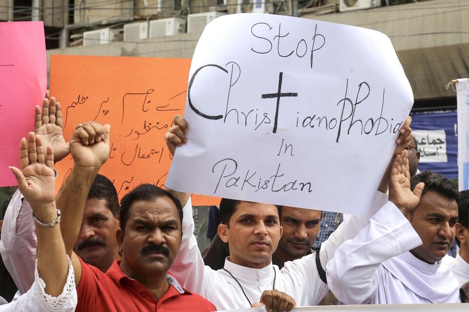 Członkowie społeczności chrześcijańskiej trzymają plakaty podczas protestu przeciwko incydentom przemocy ze strony tłumu w Faisalabadzie w Karaczi w Pakistanie / autor: PAP/EPA/REHAN KHAN