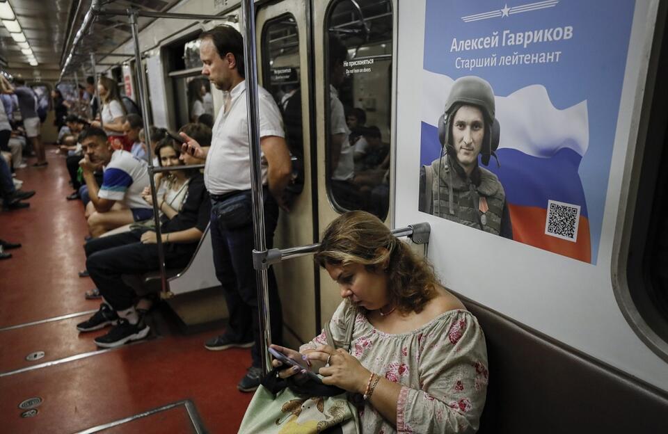 Moskiewskie metro i plakat przedstawiający rosyjskiego żołnierza / autor: PAP/EPA