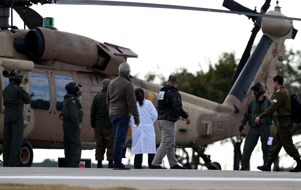 Personel medyczny i wojskowy stoi wokół helikoptera przewożącego byłego izraelskiego zakładnika Eli Sharabiego / autor: PAP/EPA