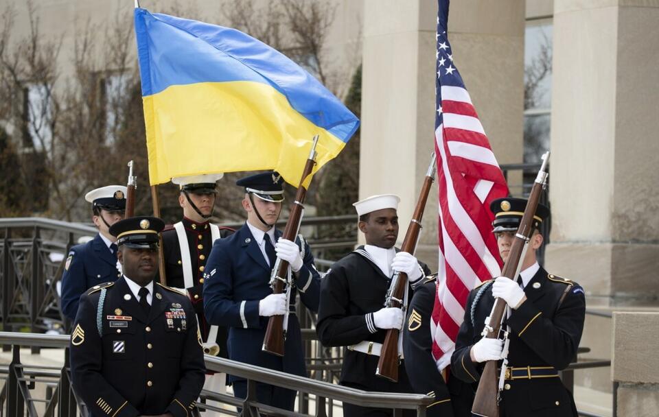 Amerykańscy żołnierze niosą flagi narodowe Ukrainy i USA / autor: PAP/EPA/MICHAEL REYNOLDS