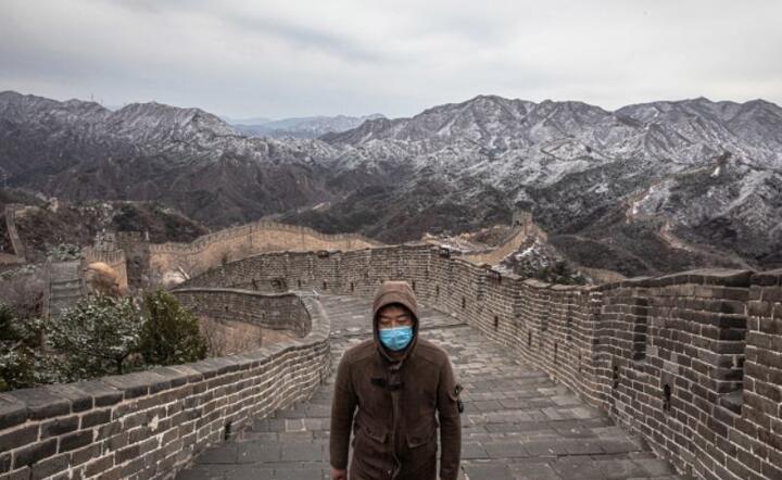 Turysta w masce ochronnej chodzi po prawie pustym Wielkim Murze, Chiny, 26 marca 2020  / autor: PAP / EPA / ROMAN PILIPEY