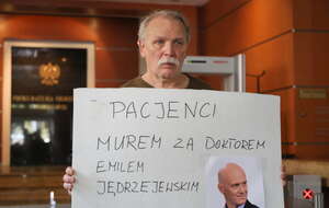 Adam Borowski z transparentem: "Pacjenci murem za doktorem Emilem Jędrzejewskim" w siedzibie Prokuratury Okręgowej w Warszawie / autor: PAP/Paweł Supernak