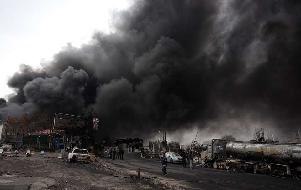 Kłęby dymu nad główną bramą rafinerii ropy naftowej Shahran w Teheranie w Iranie / autor: PAP/EPA/ABEDIN TAHERKENAREH