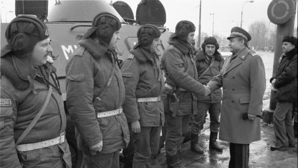 Sylwester 1981, "Solidarność" zdławiona, rządzi moskiewska junta. Generał brygady Jerzy Ćwiek składa życzenia noworoczne grupie funkcjonariuszy MO trzymających wartę przy Rondzie Waszyngtona (fot. PAP/CAF/Mariusz Szyperko)