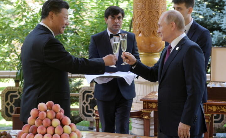 Prezydent Chin Xi Jinping i prezydent Rosji Władimir Putin wznoszą toast na 66. urodzinach chińskiego przywódcy / autor: PAP/ EPA/ALEXEI DRUZHININ / SPUTNIK / KREMLIN POOL