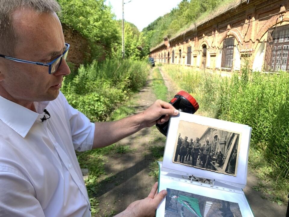 Dr Piotr Oleńczak pokazuje niemieckie fotografie z Fortu III. / autor: M. Czutko