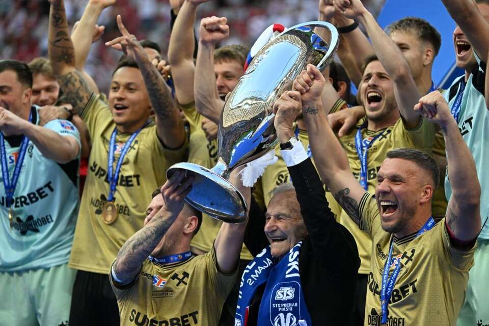 Były zawodnik Górnika Zabrze Stanisław Oślizło (C) i Lukas Podolski (P) podczas dekoracji medalowej po meczu finałowym piłkarskiego Pucharu Polski z Rakowem Częstochowa na PGE Narodowym w Warszawie. / autor: PAP/Piotr Nowak