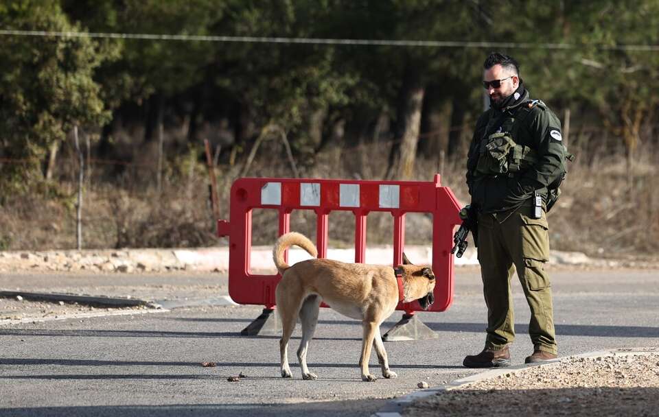 Izraelski żołnierz blokuje drogę prowadzącą do granicy Izraela z Syrią / autor: PAP/EPA/ATEF SAFADI